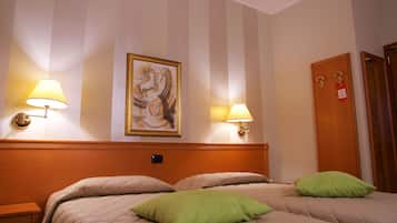 Camera d'albergo con un letto grande, due lampade ai comodini, un quadro incorniciato appeso al muro e una porta in legno con serratura a chiave elettronica.