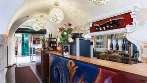 Eine Bar mit einer Holztheke, dekorativer Beleuchtung und einem Weinkühlschrank.