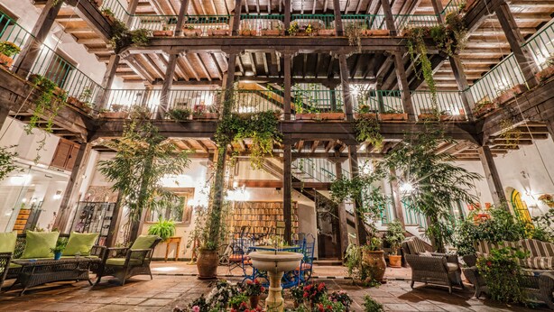 Un atrium à plusieurs niveaux, agrémenté de poutres en bois, de plantes en pot et d’espaces aménagés pour s’asseoir.