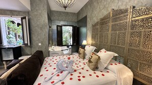 Une chambre à coucher avec un lit, une baignoire, une fenêtre et un mur décoratif.