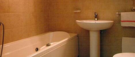 A bathroom with a bathtub, sink, and toilet.