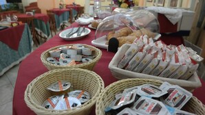 A buffet setup with various food items and condiments. - Hotel 4 Mori (Cagliari)