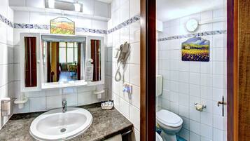 Ein Badezimmer mit Waschbecken, Spiegel und Toilette.