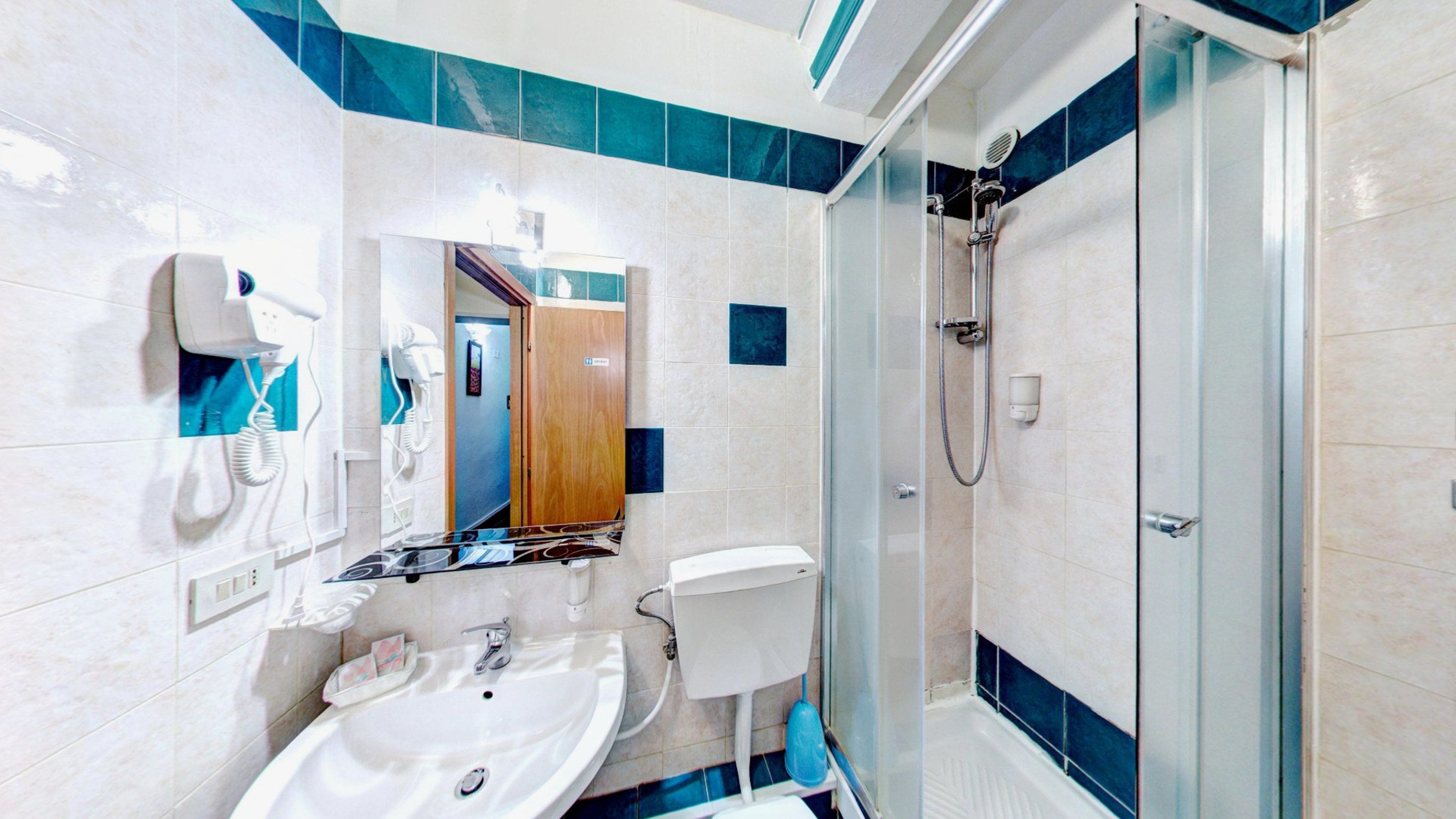 Une salle de bain moderne équipée d’un lavabo, de toilettes et d’une douche.