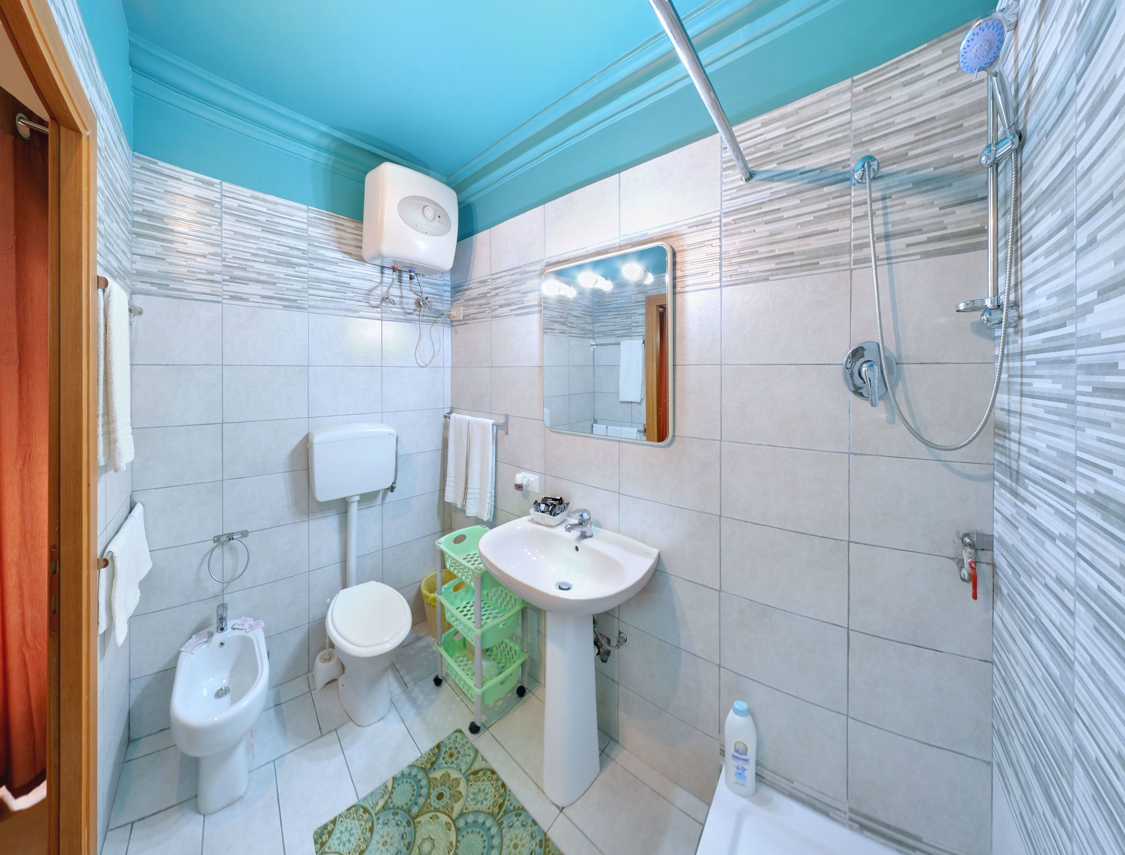Ein Badezimmer mit Toilette, Bidet, Waschbecken, Dusche und einem Handtuchhalter.
