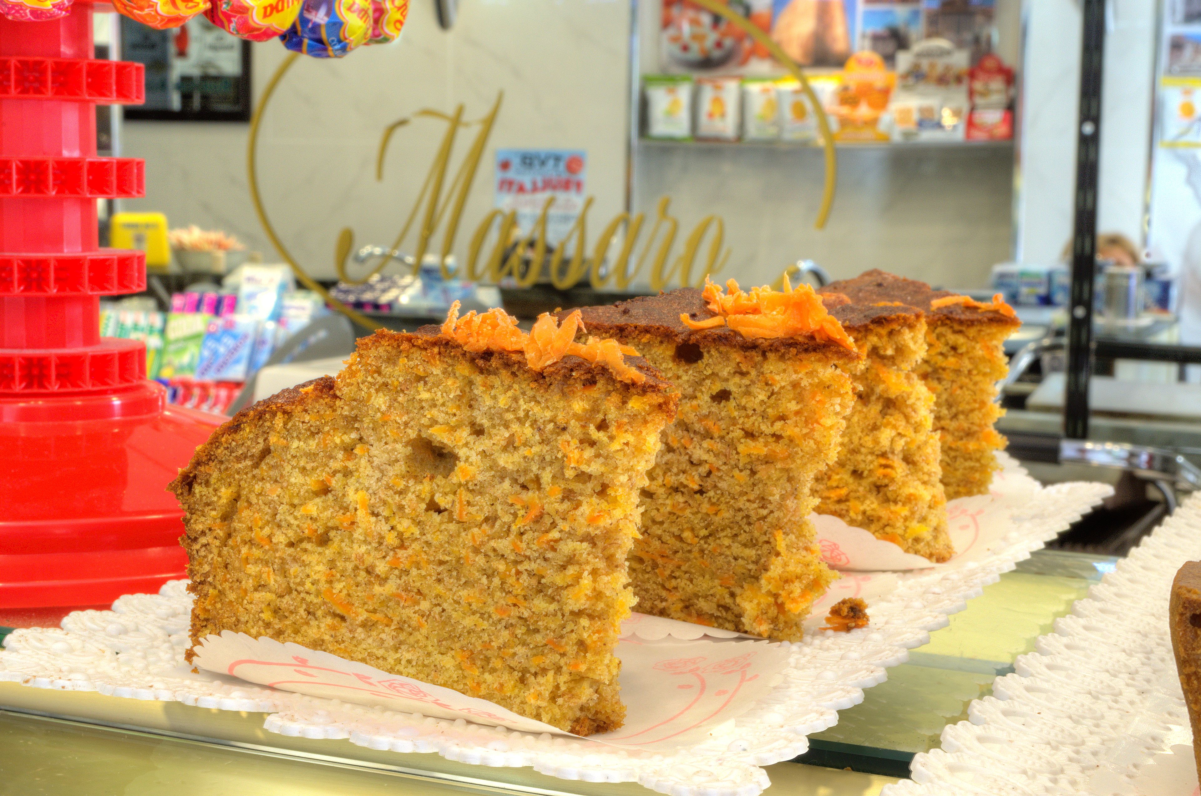 A display of carrot cake slices on a tray with a white doily underneath.