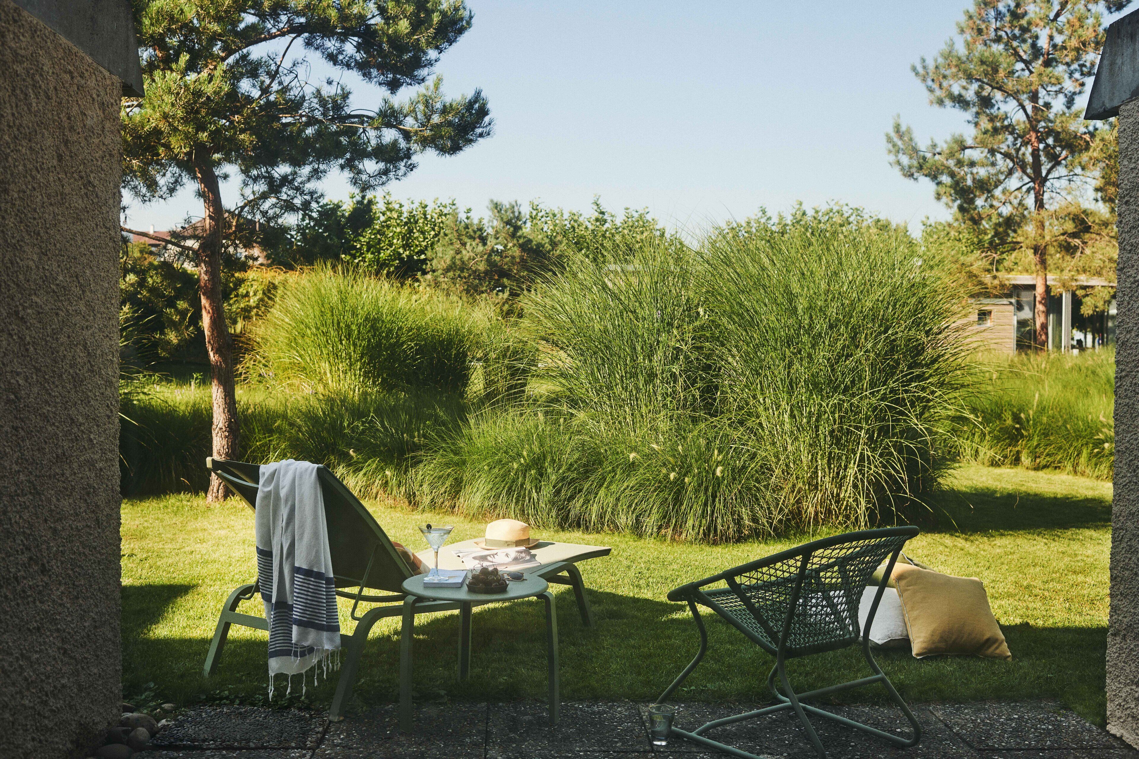 An outdoor seating area with a table, chairs, and a blanket.