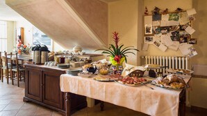 Una mesa de buffet con diversos platos y un tablón de anuncios con fotos y notas.