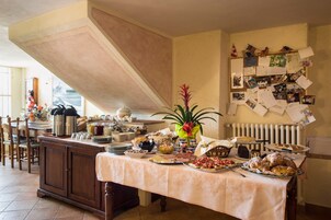 Un tavolo per buffet con diversi piatti e una bacheca con foto e appunti.