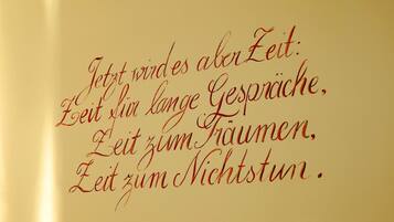 Eine Wand mit einem deutschen Zitat über die Zeit.
