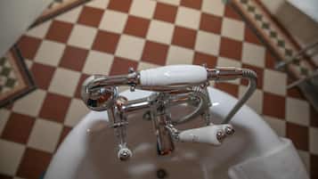 A bathroom with a checkered floor pattern and a white bathtub.