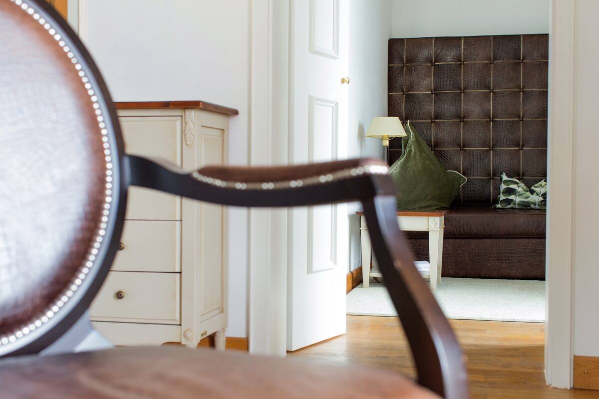 Ein Zimmer mit einem braunen, gepolsterten Kopfteil, einem grünen Kissen und einer weißen Tür.