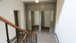 A hallway with a wooden staircase, a light fixture, and doors numbered 307-316. - Hotel du Marche (Lausanne)