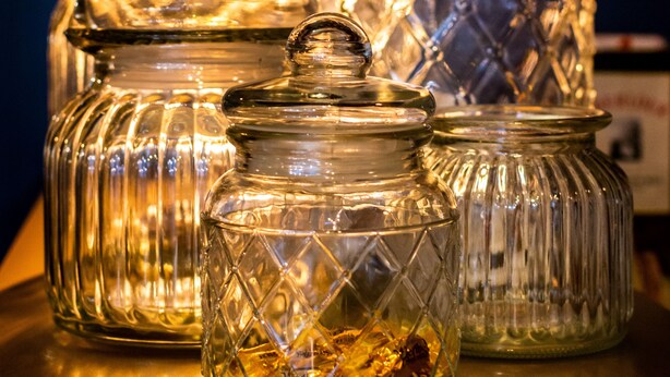 A row of glass jars with lids on a wooden surface. - Best Western Hotel Graslin (Nantes)