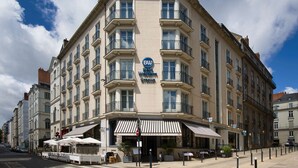 A corner building with a sign reading "Best Western" and a restaurant with outdoor seating. - Best Western Hotel Graslin (Nantes)