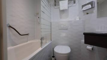 Un bagno con vasca, WC e box doccia in vetro.