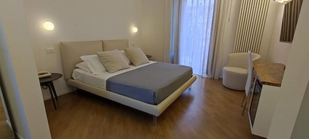Una camera da letto con un letto, comodini, una sedia e una scrivania.