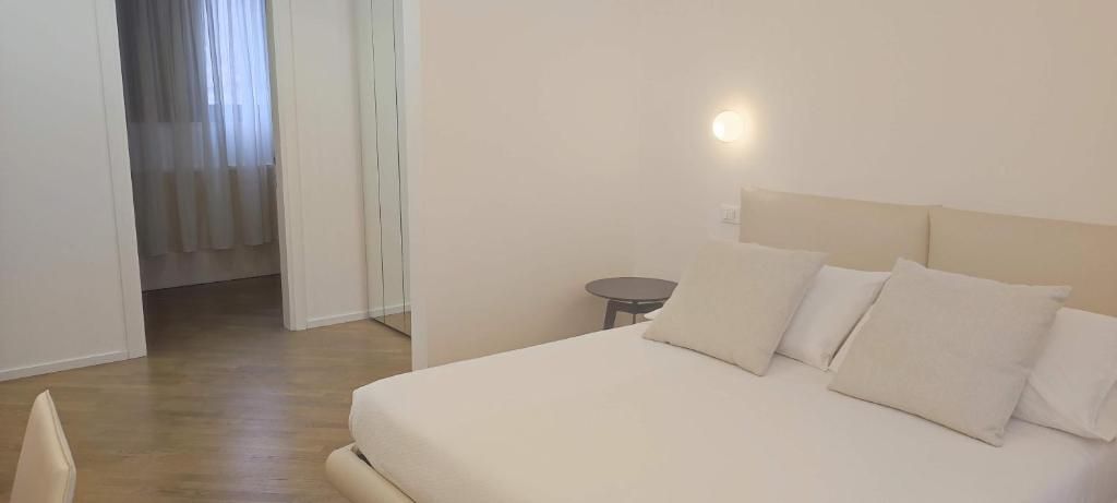 A hotel room with a bed, a small round table, and a door leading to another room.