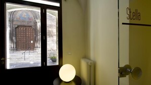 Una habitación con ventana, un radiador y una puerta con el rótulo 'Stella'.