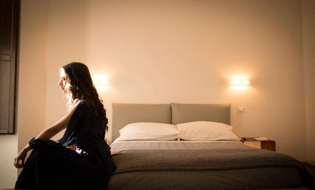 Ein Zimmer mit einem Bett, zwei Nachttischlampen und einem Nachttisch mit einem Buch.