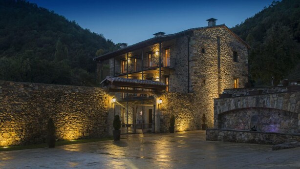 A stone building with a balcony and a sign that reads "Hotel". - Rusticae La Casassa de Ribes (Ribes De Freser)