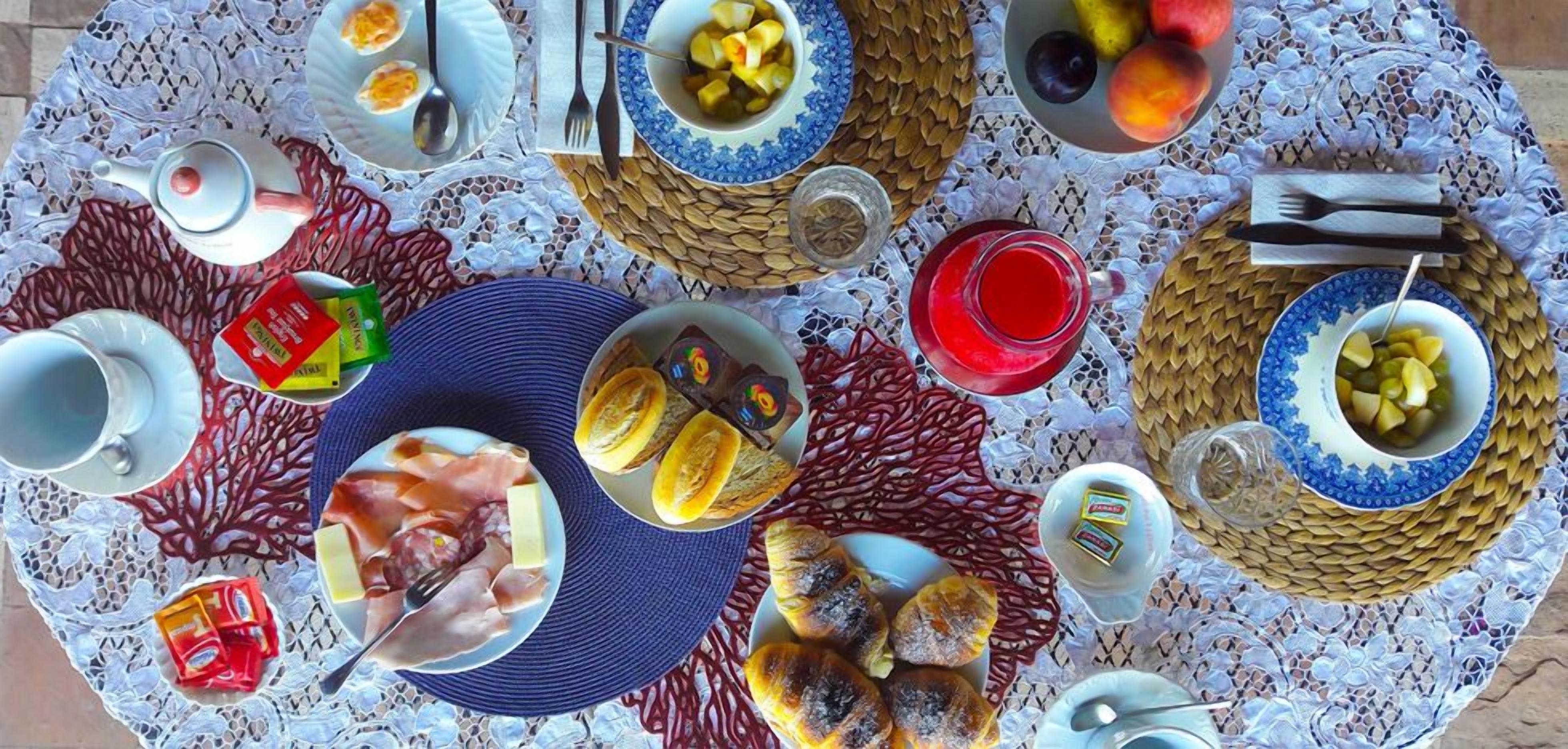 A table set with various food items, plates, and utensils, suggesting a meal setup.
