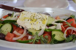 A plate of Greek salad with feta cheese, cucumbers, tomatoes, and olives. - Faros Villa small hotel & restaurant (Naxos)