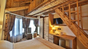 A wooden cabin-style bedroom with a bed, a desk, and a television. - Pilier d'Angle (Courmayeur)