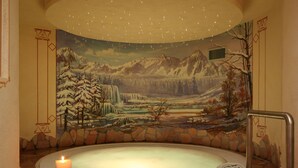 A spa area with a hot tub, a candle, and a mural of a snowy mountain landscape. - Pilier d'Angle (Courmayeur)