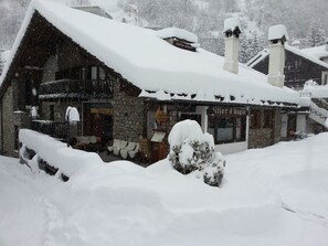 A stone building with a snow-covered roof and a sign that reads "Hôtel d'Angleterre." - Pilier d'Angle (Courmayeur)