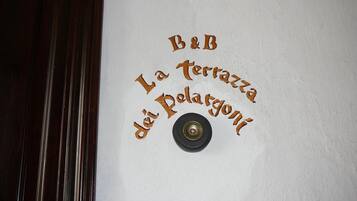 Eine Wand mit dem Schriftzug „B&B La Terrazza dei Polargoni“ und einem Klingelzeichen.
