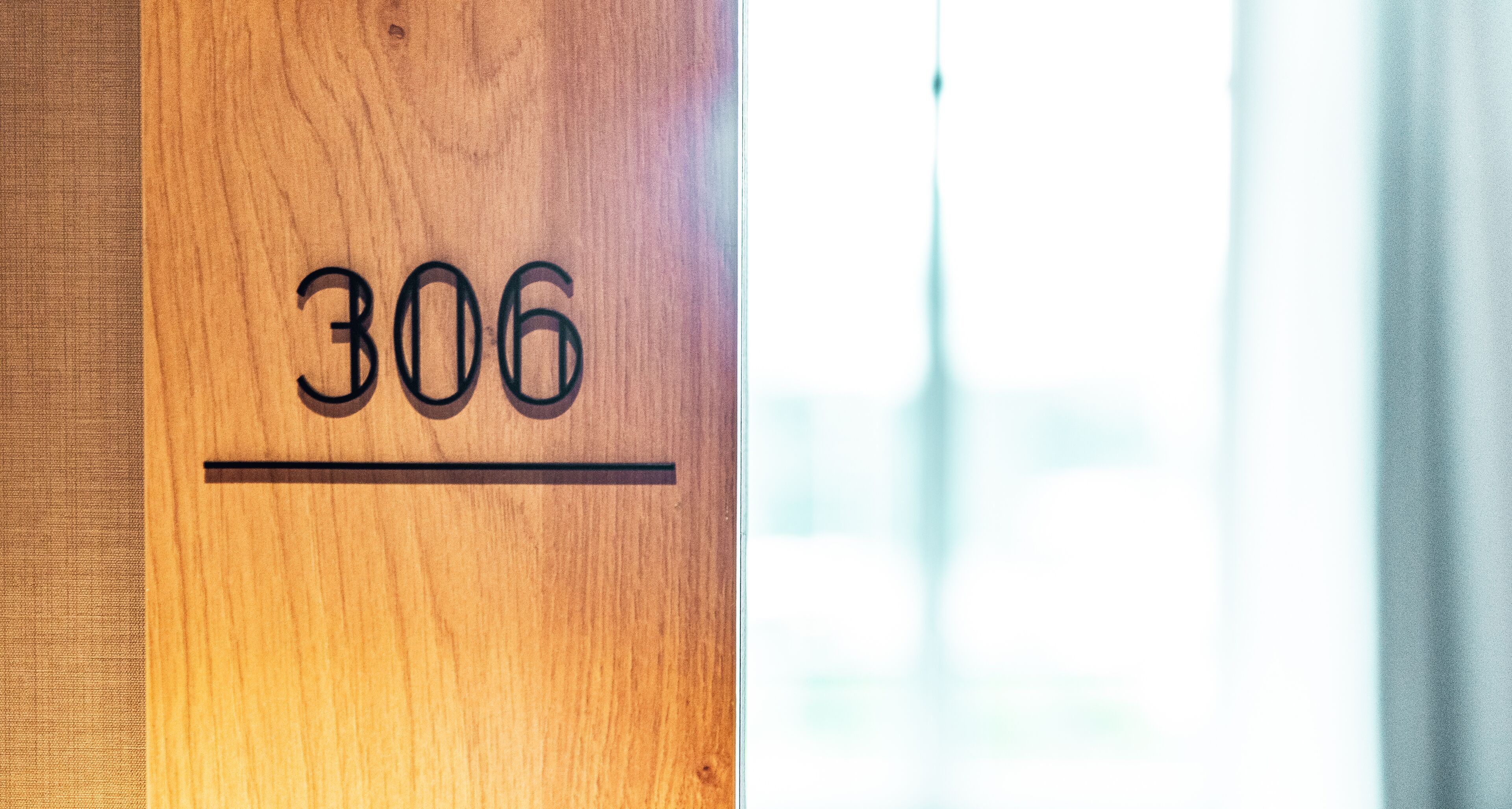 Uma porta de madeira com o número 306 gravado.