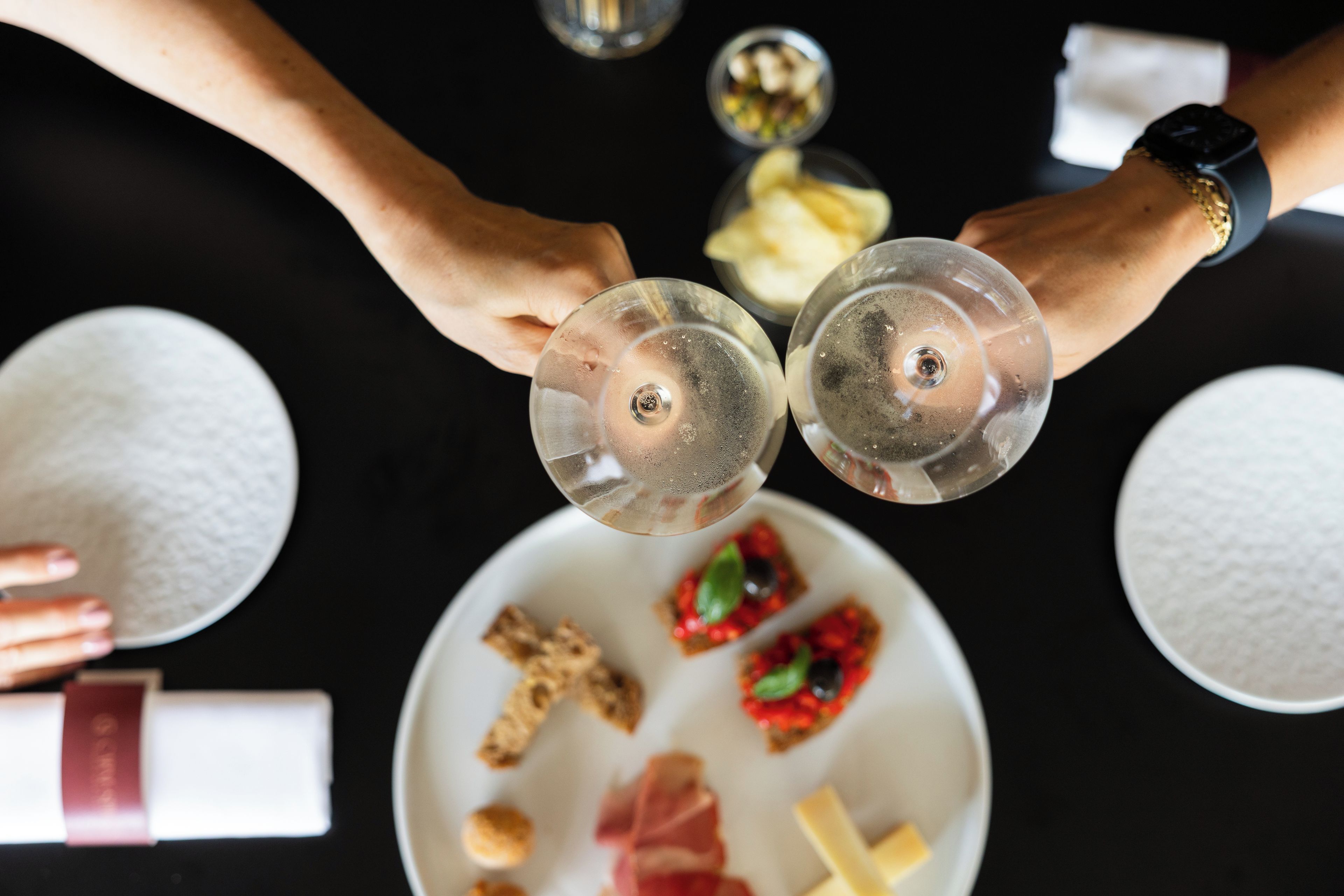 Vue d’ensemble d’une table à manger, avec deux verres à vin, une assiette contenant de la nourriture et un bol de riz.