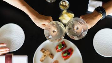 Vue d’ensemble d’une table à manger, avec deux verres à vin, une assiette contenant de la nourriture et un bol de riz.