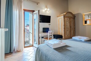 A hotel room with a bed, a desk with a computer, a wardrobe, and a bathroom visible through an open door. - Hotel Noce (Brescia)