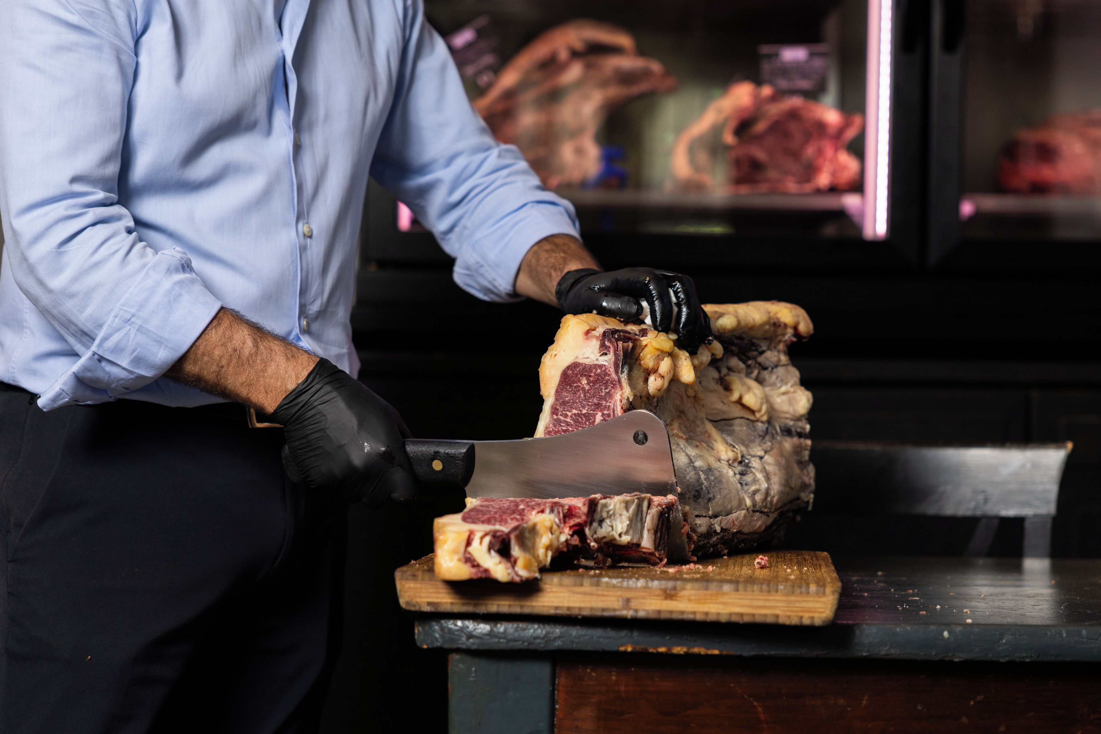 A person slicing meat on a cutting board.