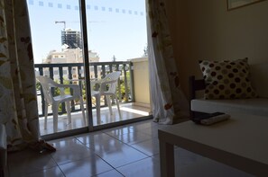 A room with a balcony, a sofa, and a table. - Lordos Hotel Apartments (Limassol)