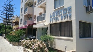 Um hotel chamado 'LORDOS HOTEL GROUP', com fachada moderna, varandas e entrada visível.