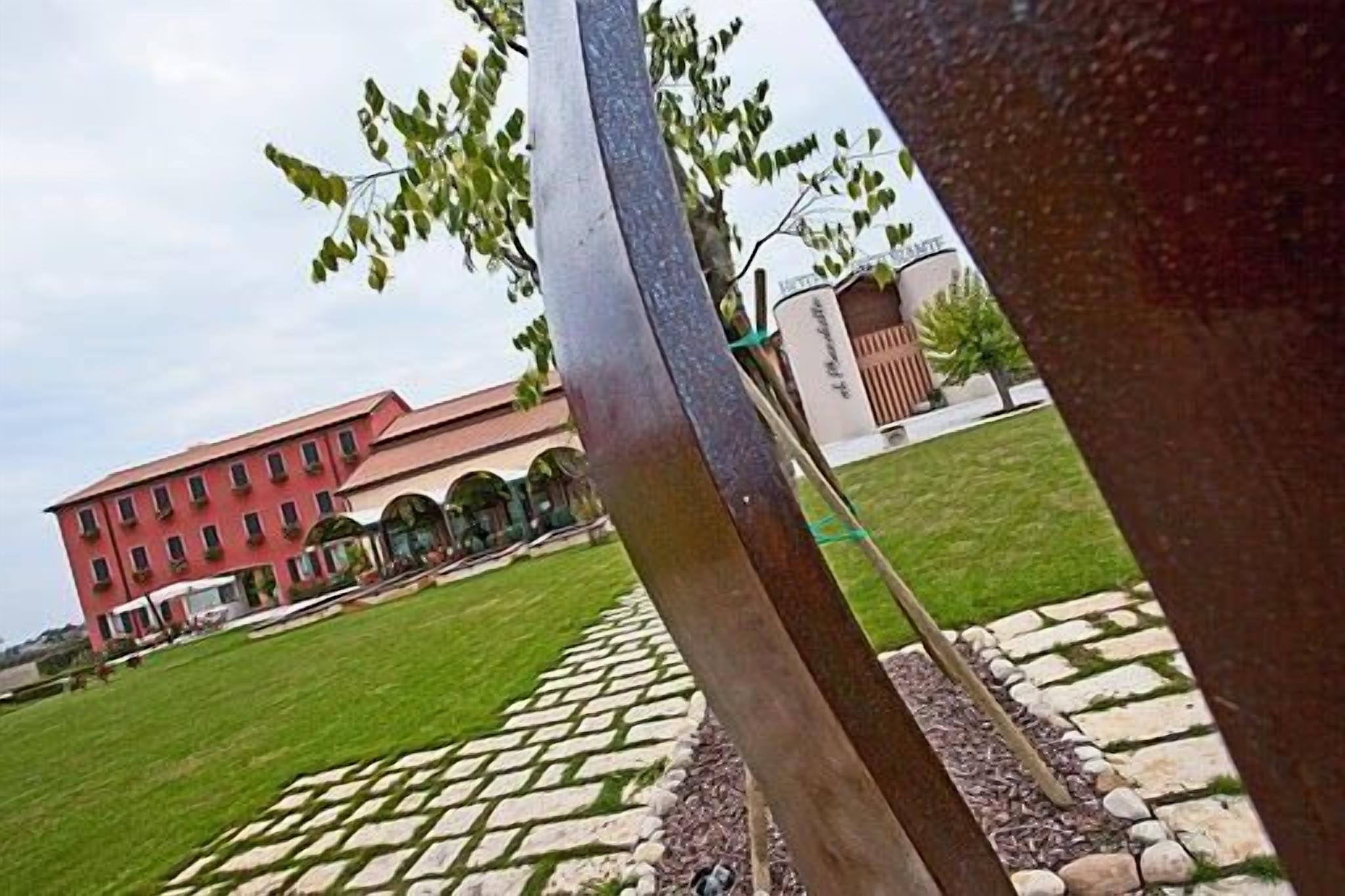 A building with a red facade, a paved courtyard, and a stone pathway.