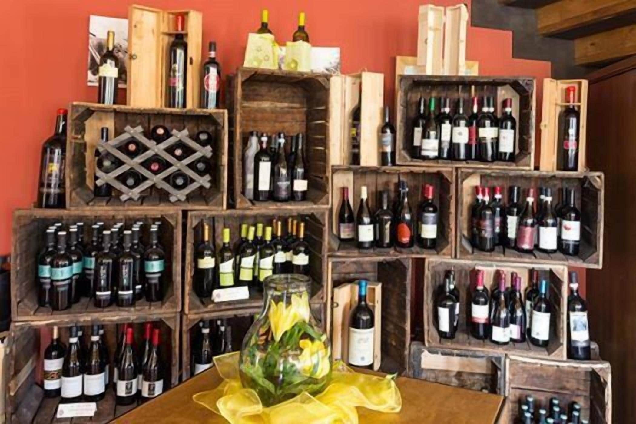 Una bodega con cajas de madera llenas de diversas botellas de vino.