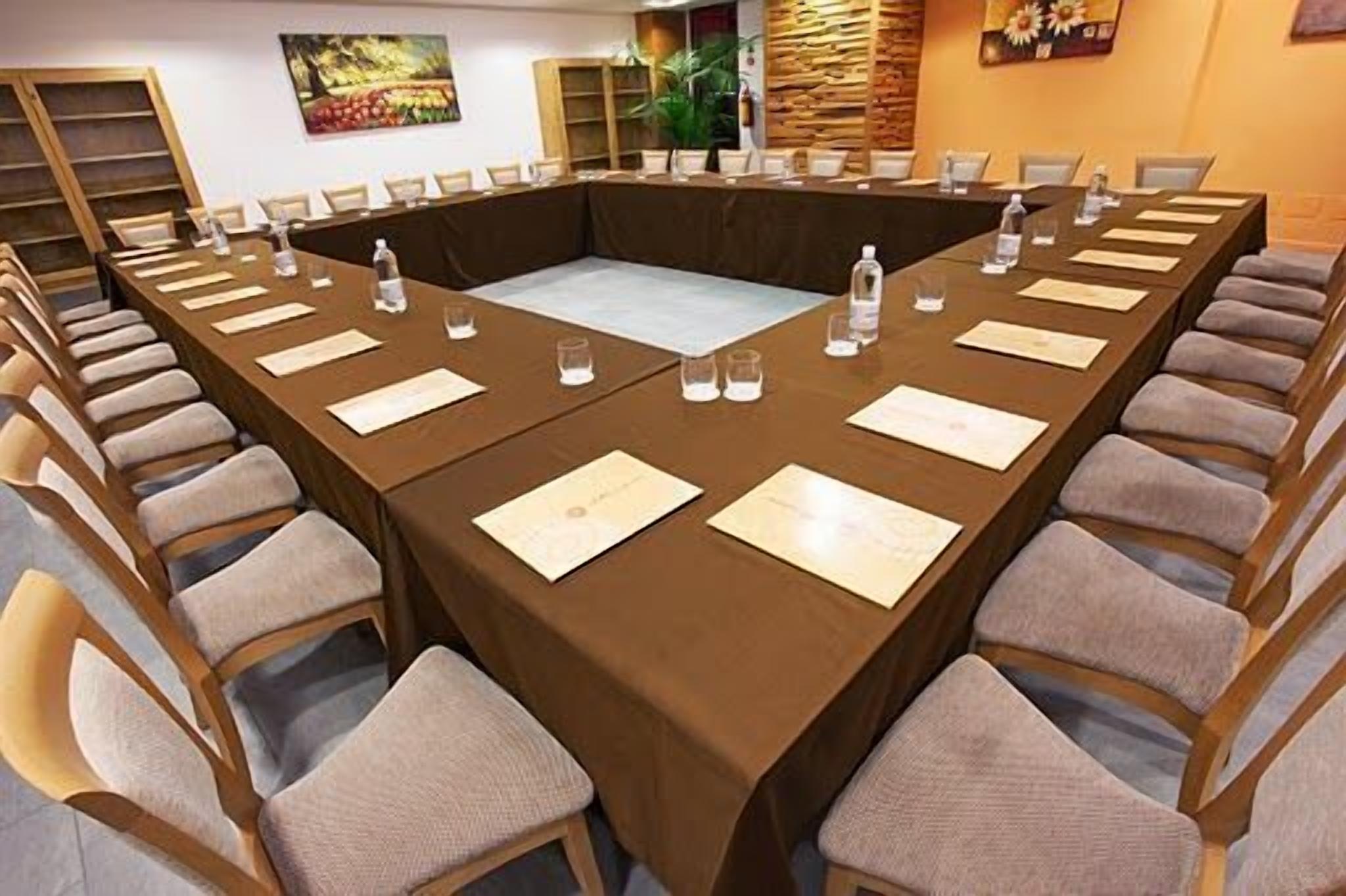 Ein Konferenzraum mit einem langen Tisch, Stühlen, Wasserflaschen und Namensschildern.