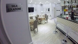 A modern hotel room with a dining area, a bar, and a sign indicating the room type.