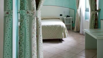 Ein Schlafzimmer mit Bett, Nachttisch und Spiegel an der Wand.
