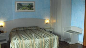 Quarto com cama, mesas de cabeceira, um guarda-roupa e prateleira na parede.