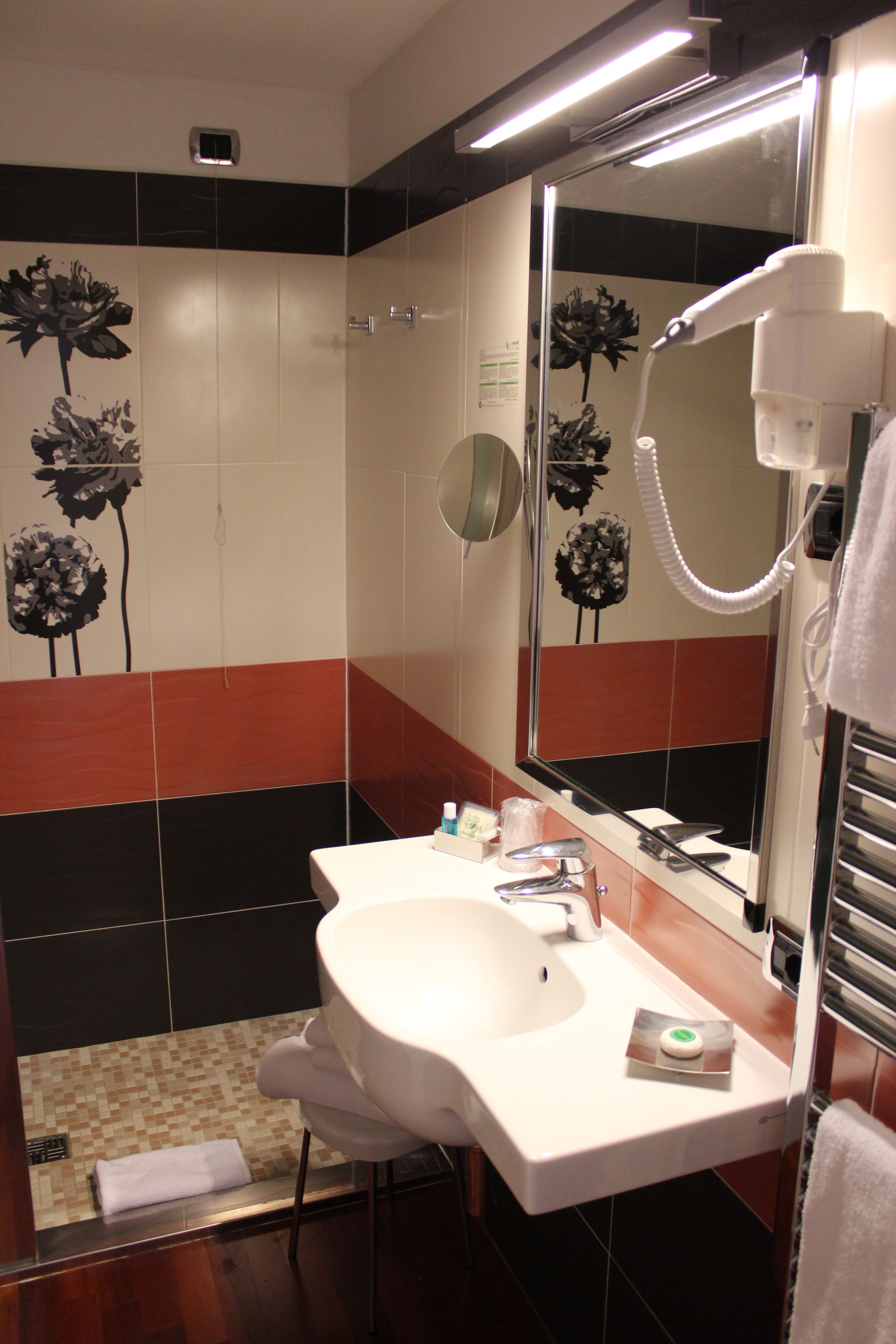 Ein Badezimmer mit Waschbecken, Spiegel und Handtuchhalter.