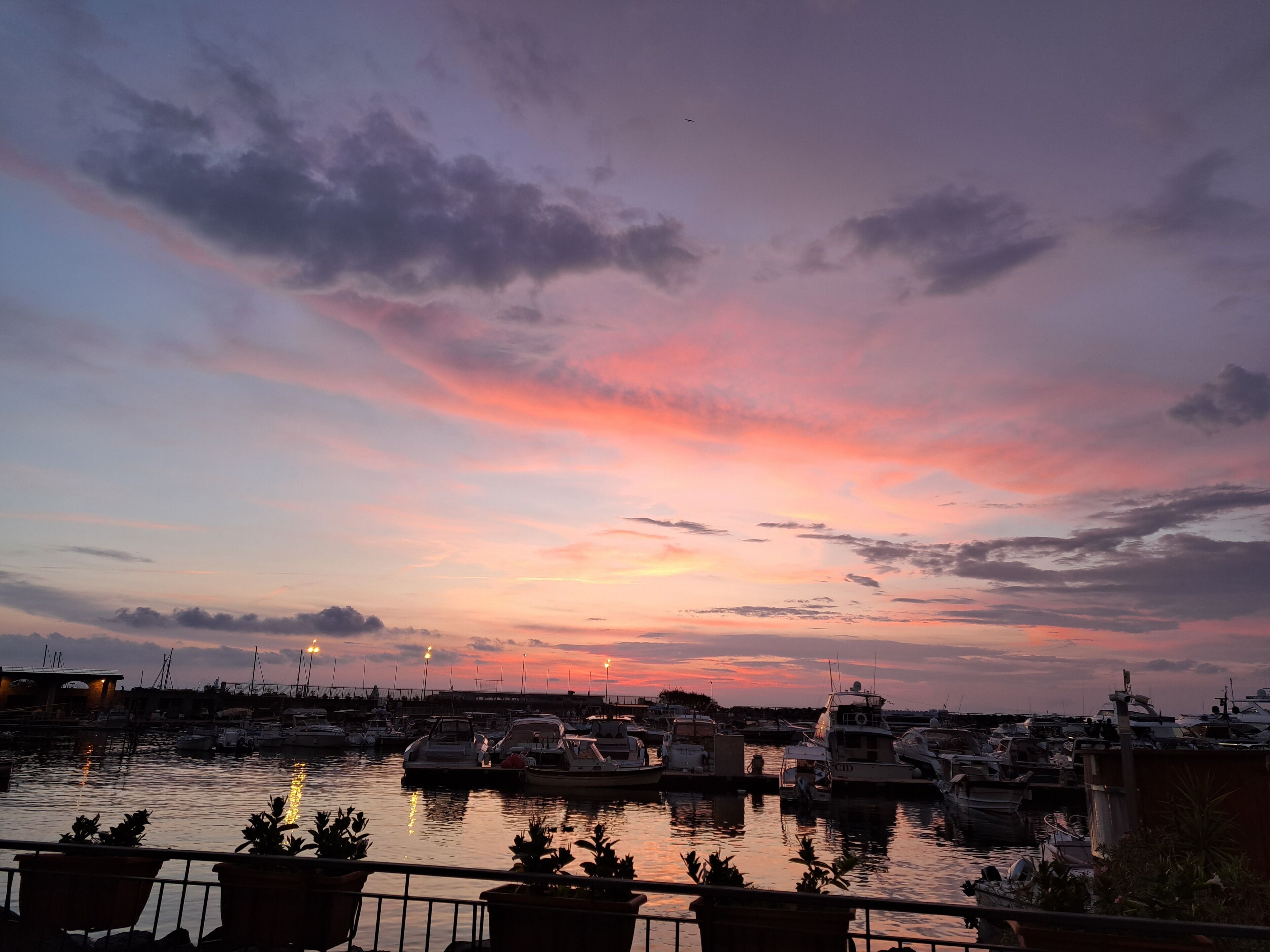 Ein Yachthafen mit vor Anker liegenden Booten im Abendrot.