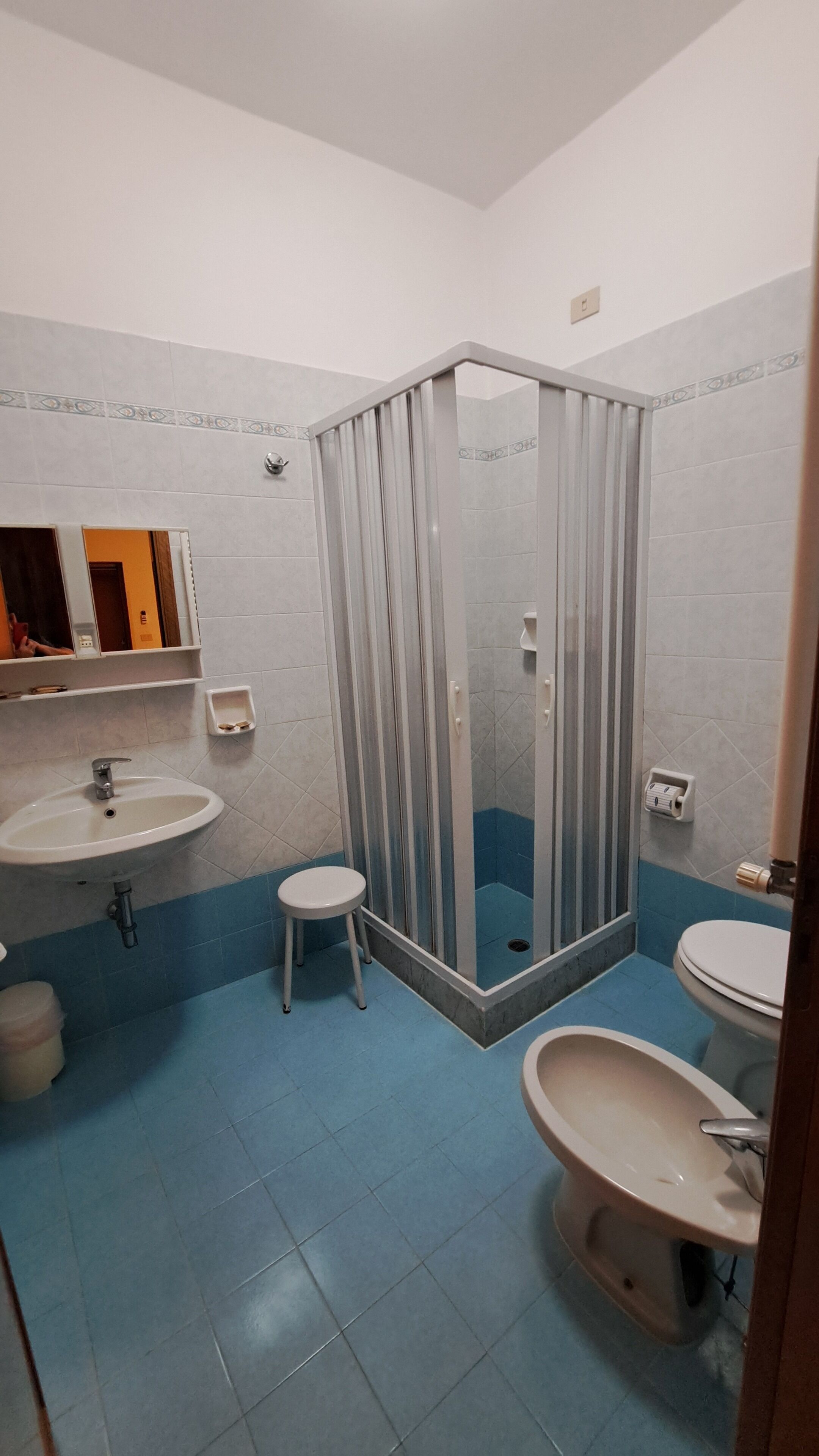 A bathroom with two sinks, a toilet, a shower enclosure, and a mirror.
