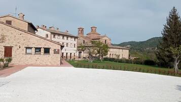A large stone building with multiple windows and a courtyard.