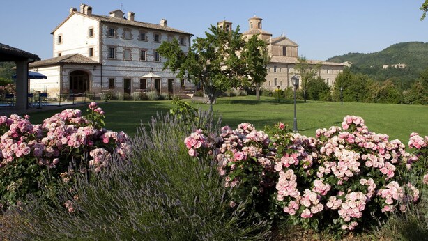 A large, historic building with a symmetrical facade, multiple chimneys, and a central entrance. - Country House Parco Ducale (Urbania)