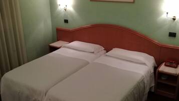 A double bed with two nightstands, a red telephone, and a painting on the wall.